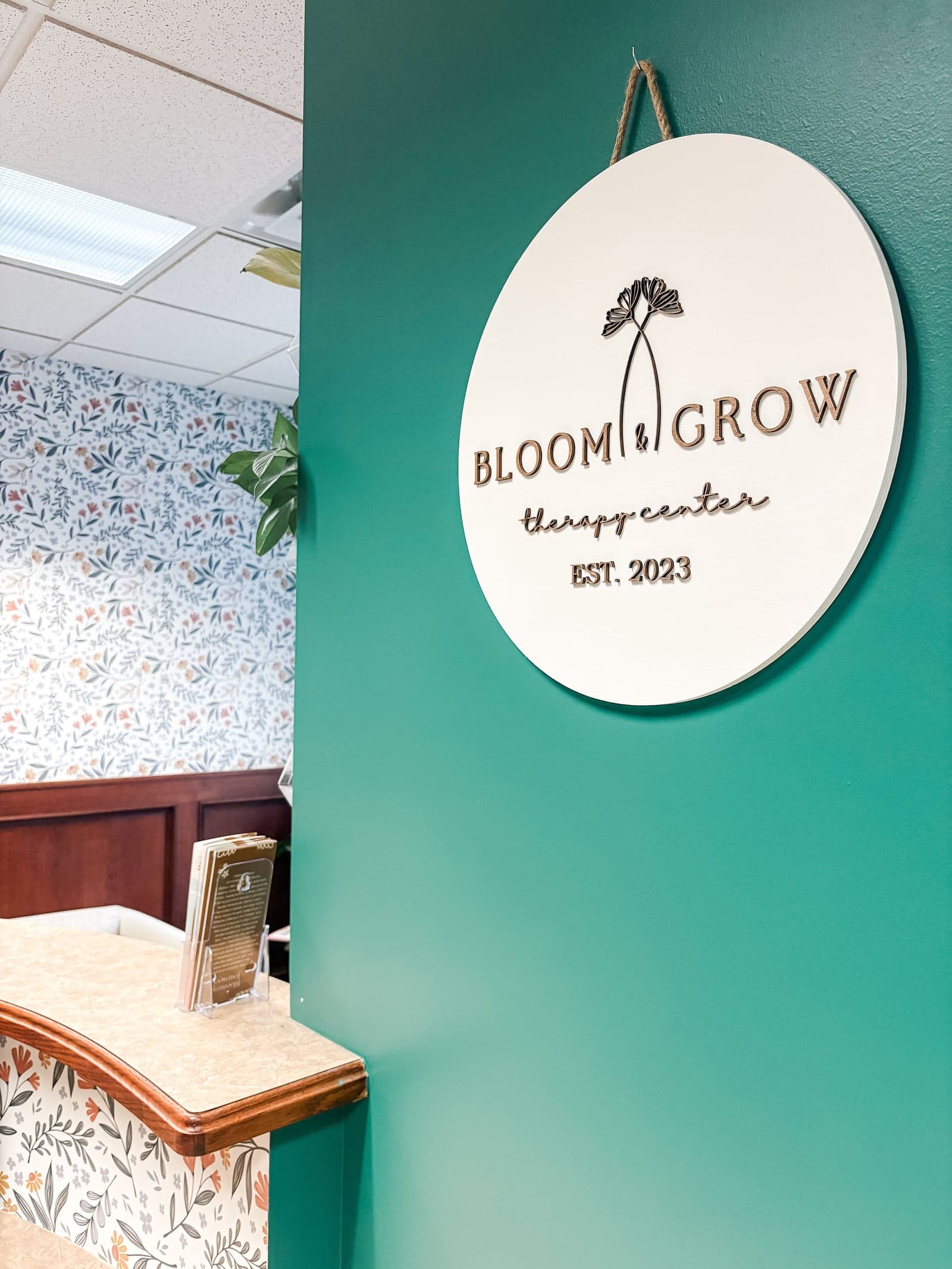 Bloom and Grow Therapy Center logo sign on wall