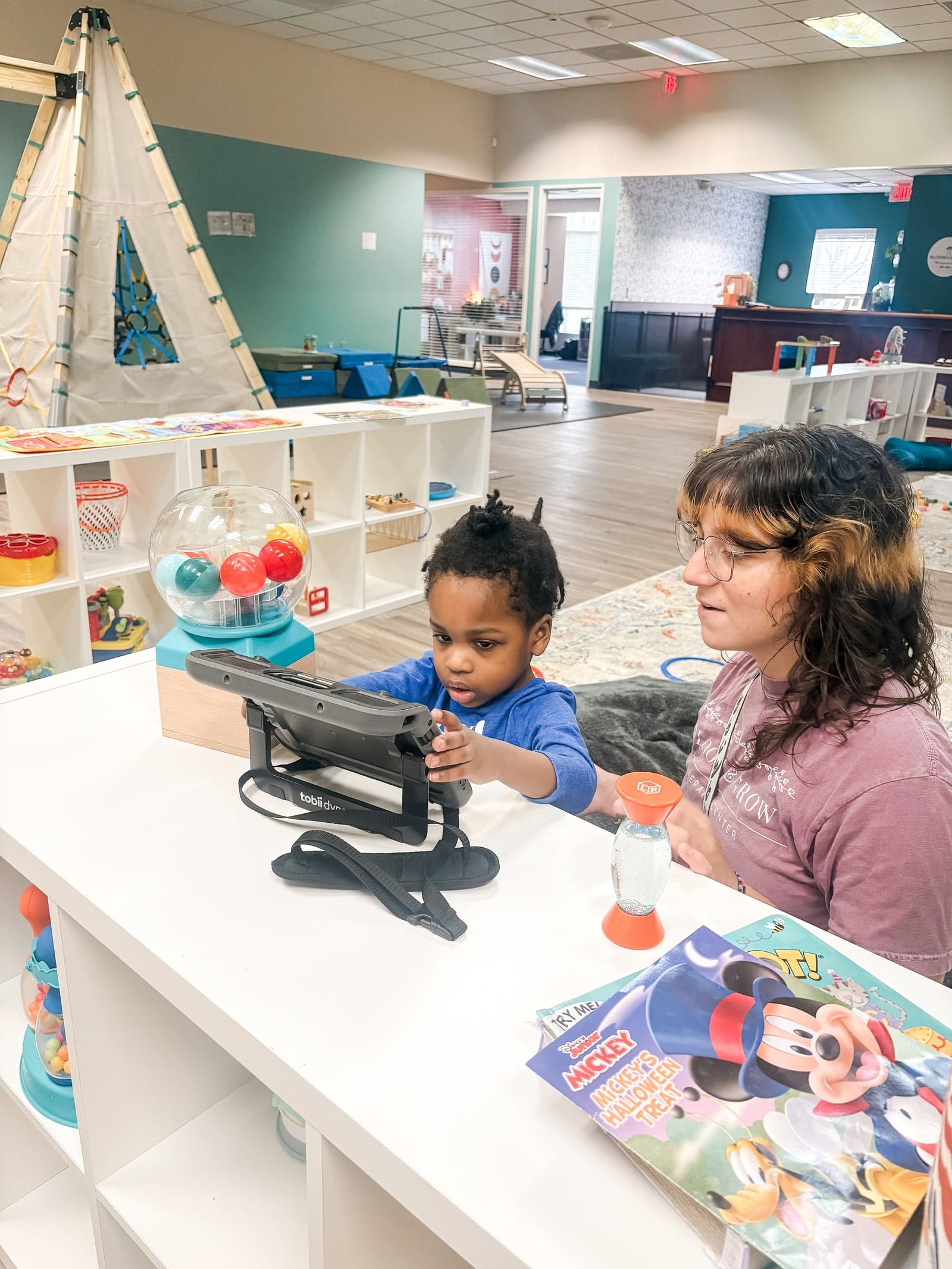 Therapist and child using AAC device at table