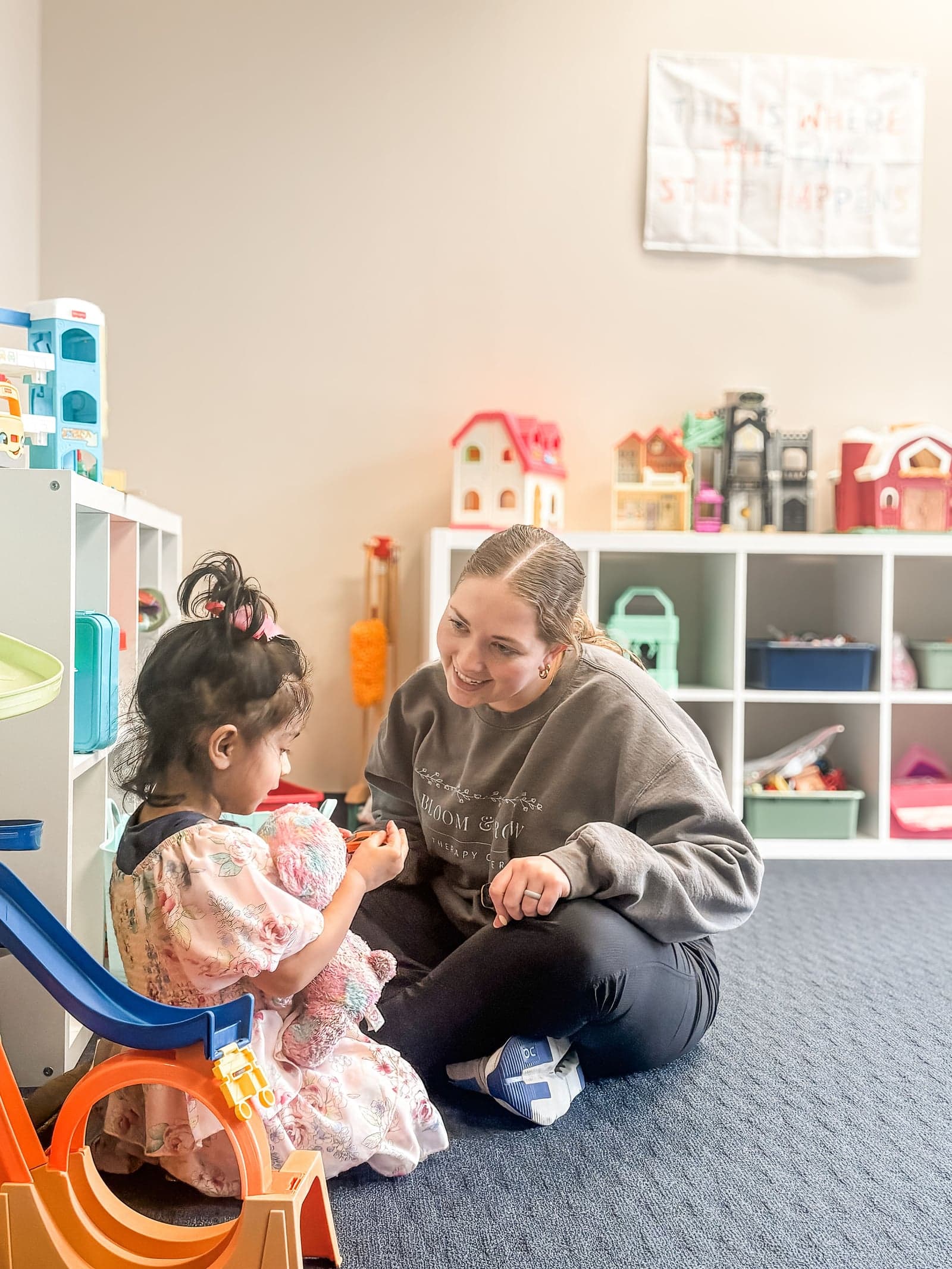 Therapist engaging toddler with toys on floor